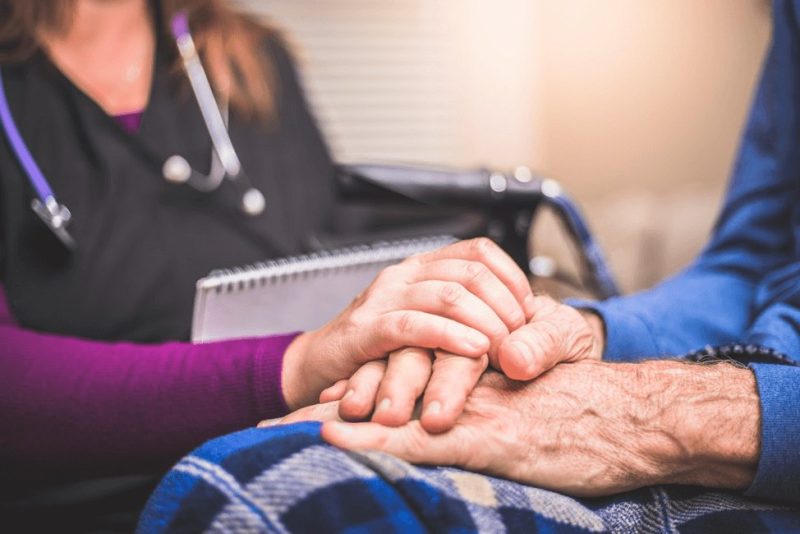 Nurse holding the hand of an older person in Washington DC