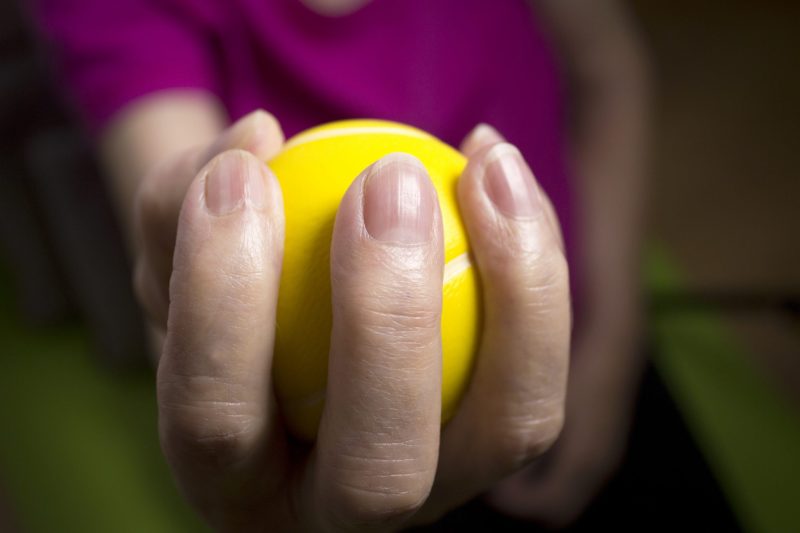 senior doing exercise squeezing a ball