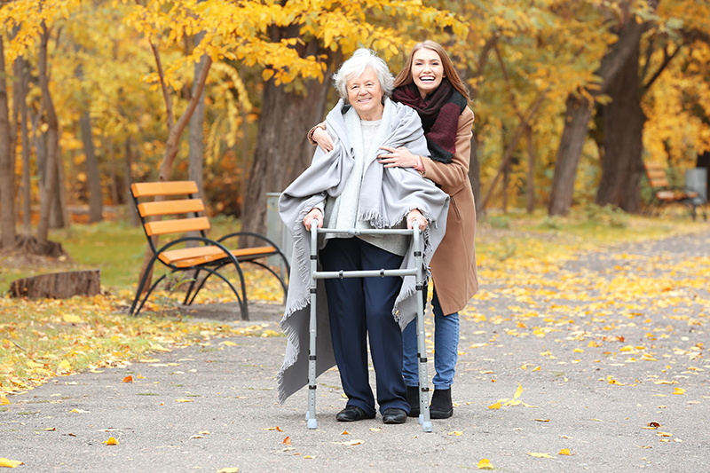 Daughter walking and supporting a senior while walking in Rockville MD