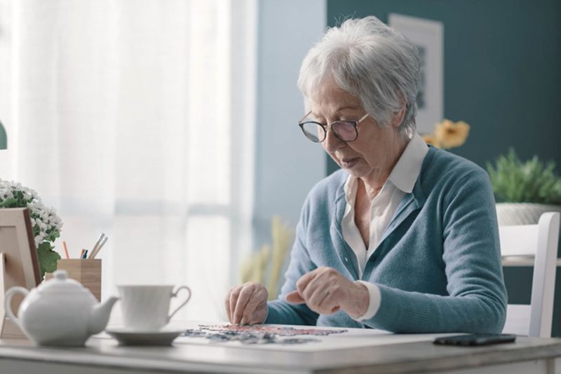 Senior solving a crossword puzzle for cognitive stimulation